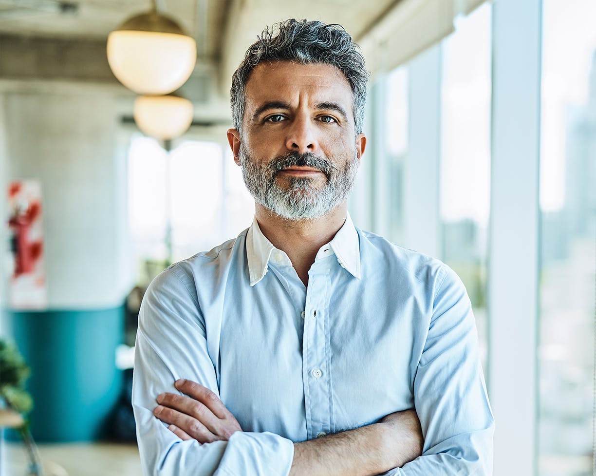 A man with a beard with his arms crossed
