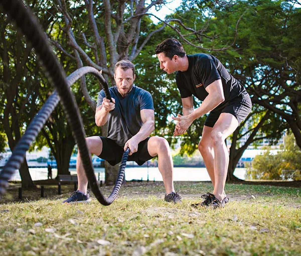 Two males using battle ropes