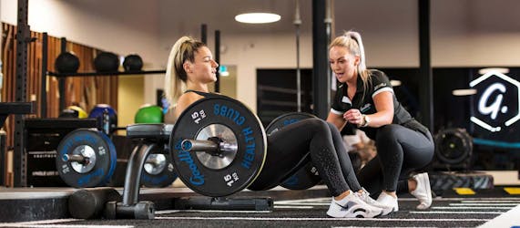Goodlife trainer helping client with weights