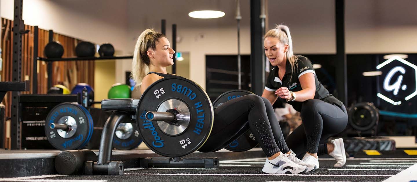 Goodlife trainer helping client with weights