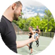 Male teaching a fitness group outside
