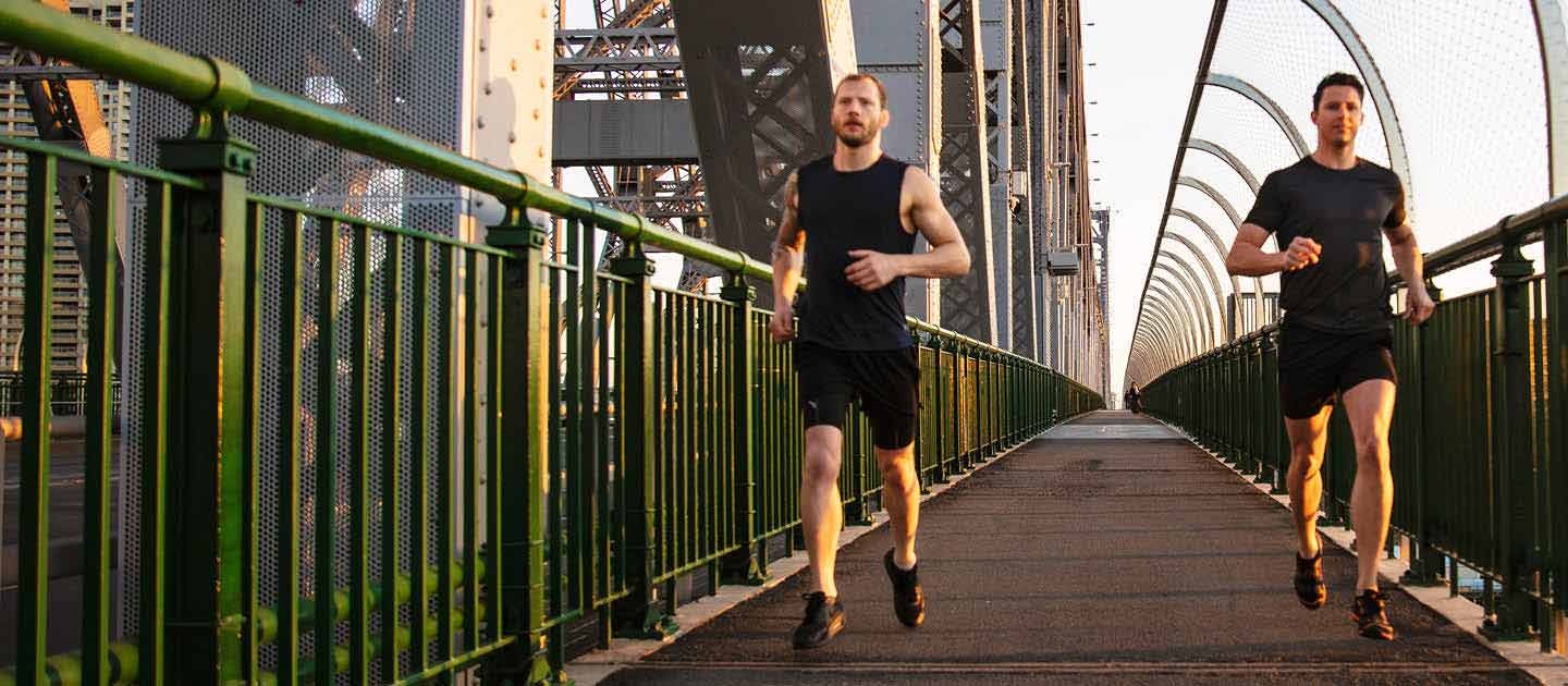 Two males running on footpath