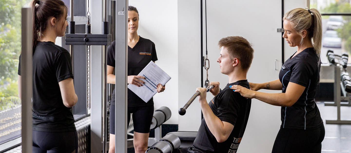 Students learning in a gym with a trainer