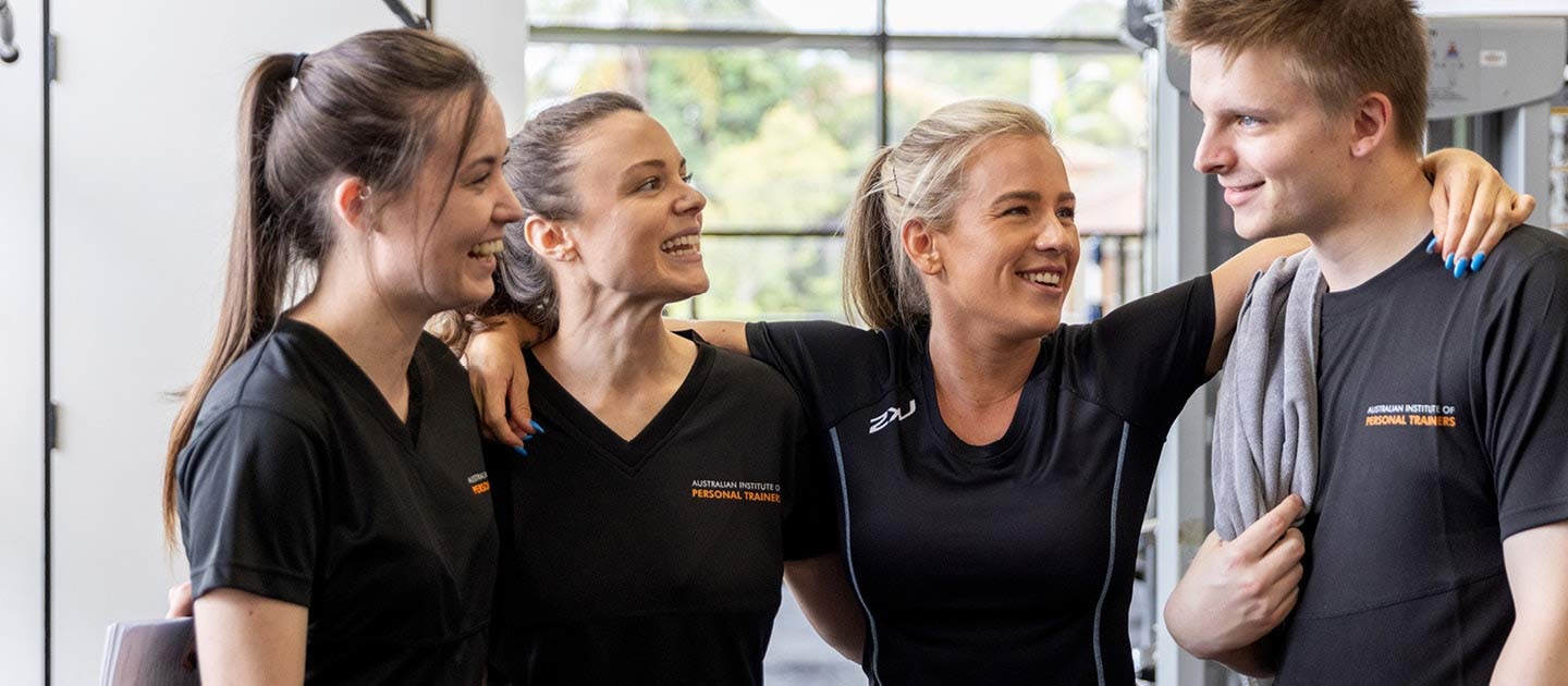 Students laughing with trainer in gym