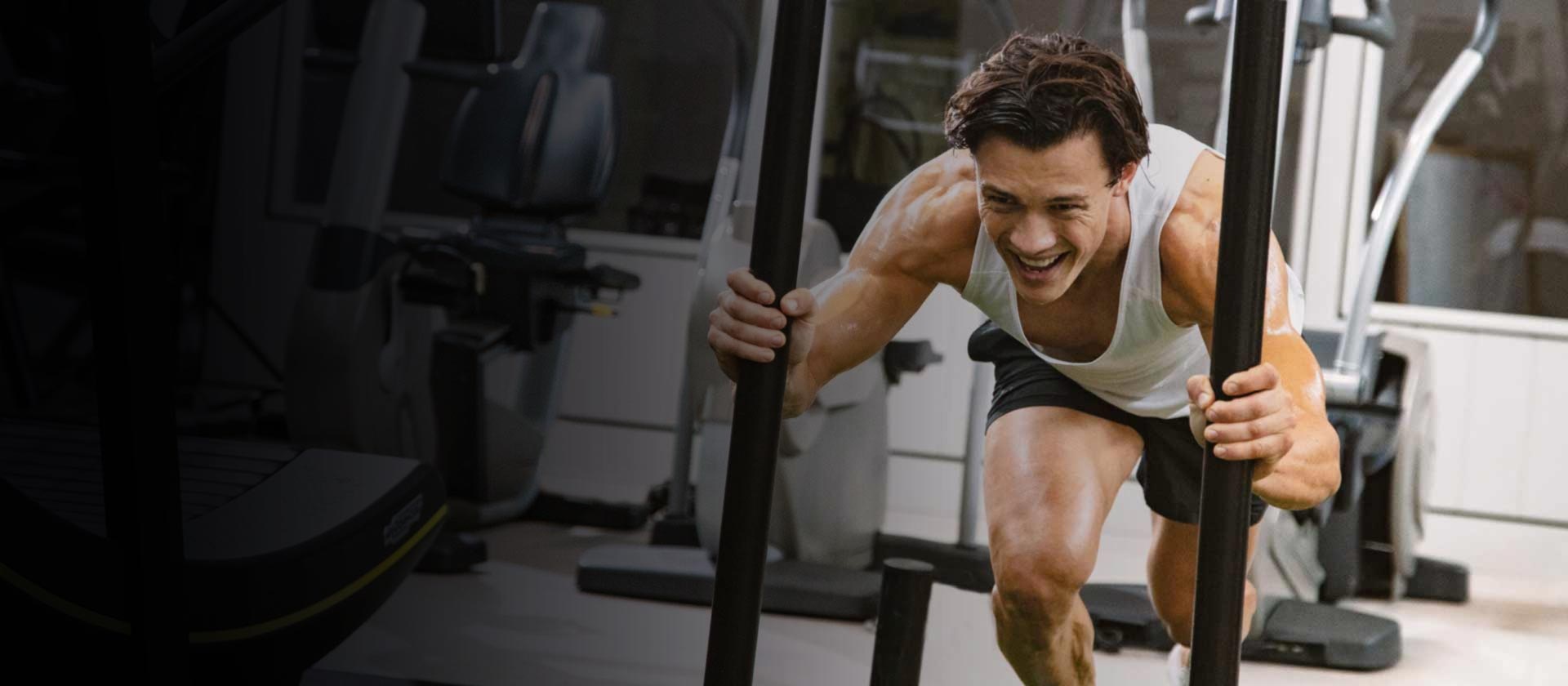 Male pushing sled in gym