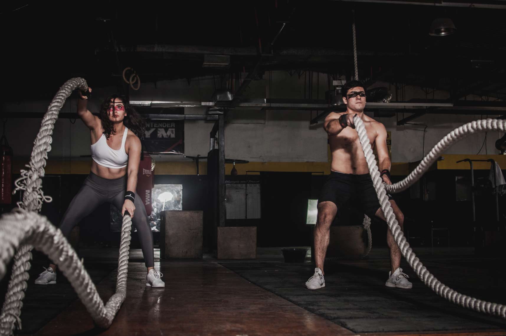 A man and woman using excerise ropes