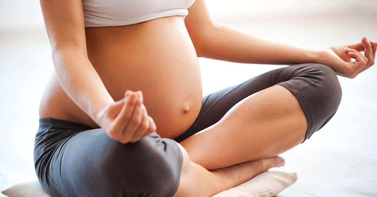 Pregnant female doing yoga 
