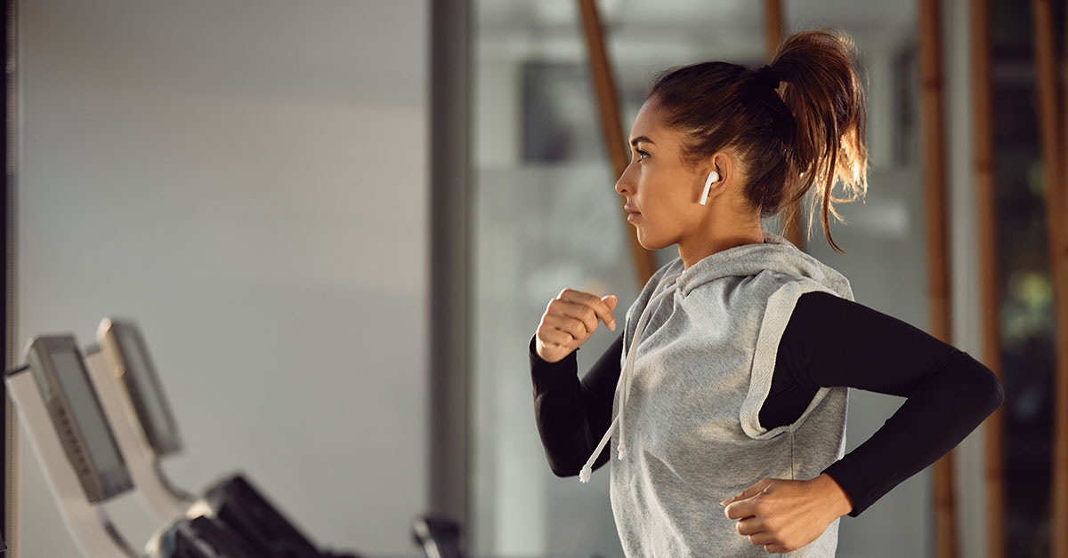 Woman listening music while running on treadmill