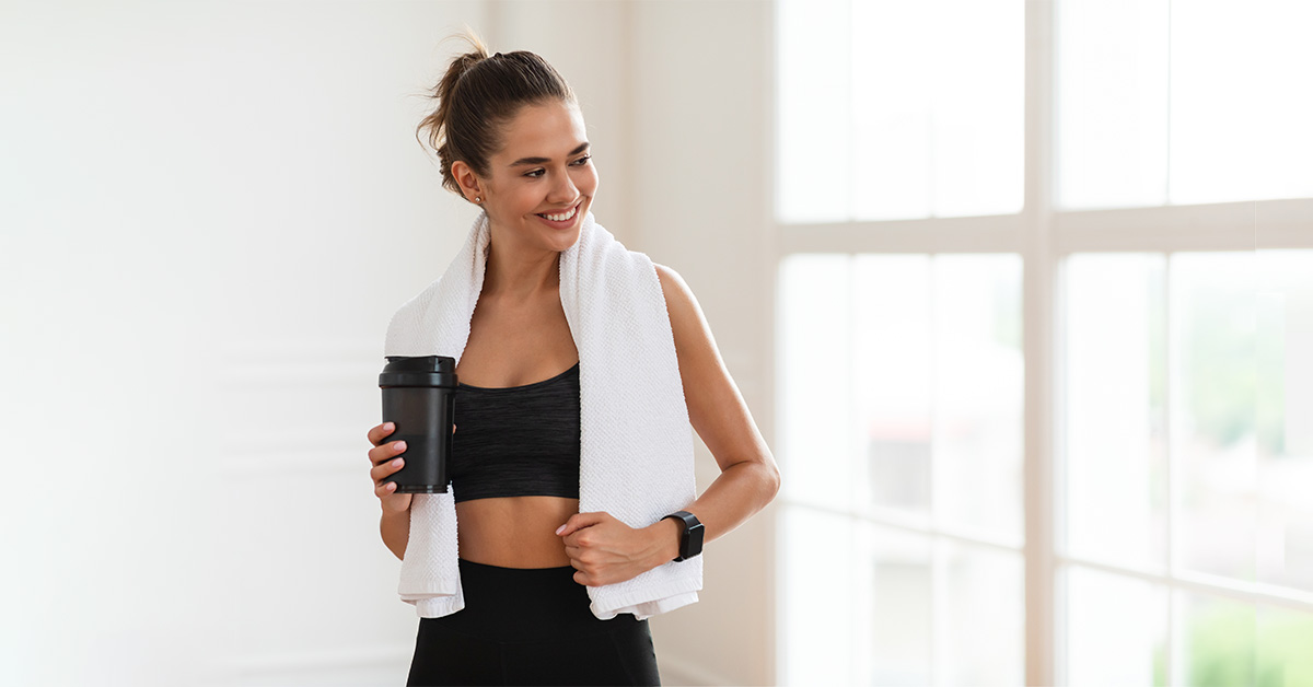 smiling lady in sportswear holding a shaker