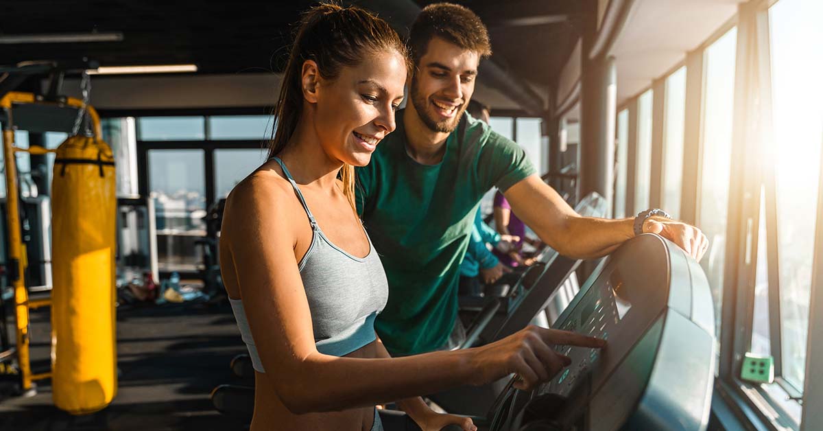 personal trainer with client at the gym