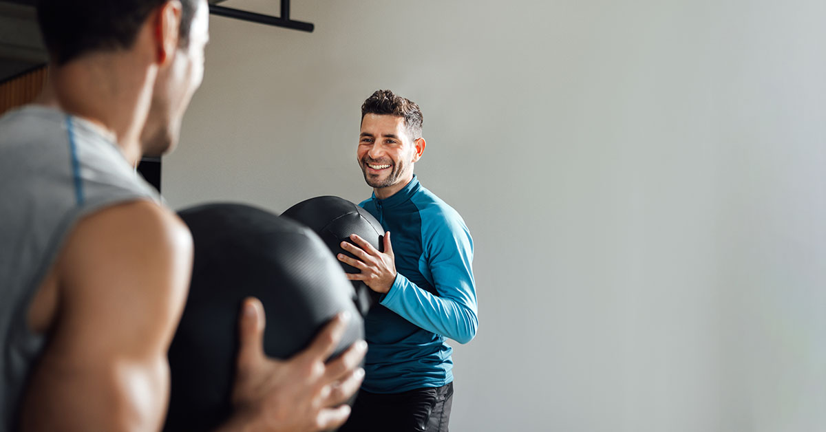 personal trainer in fitness class with medicine ball