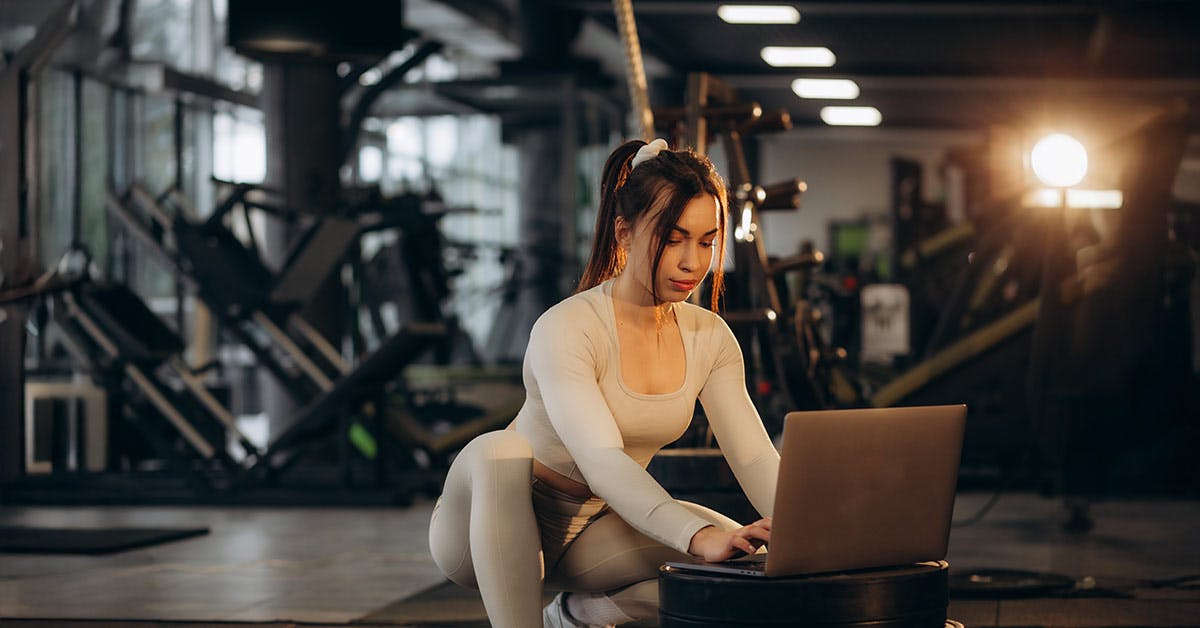 PT typing client notes on laptop