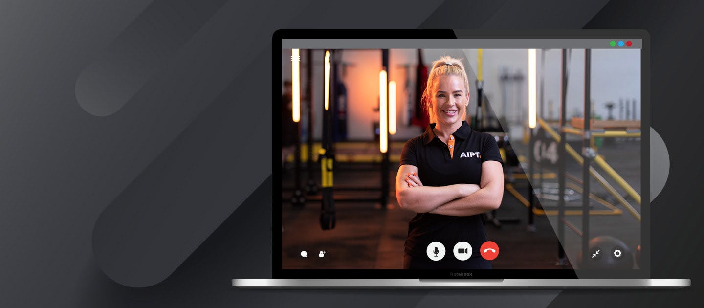 A computer screen showing a video call of an Australian Institute of Personal Trainers (AIPT) instructor smiling with arms crossed in a gym during a virtual classroom session.