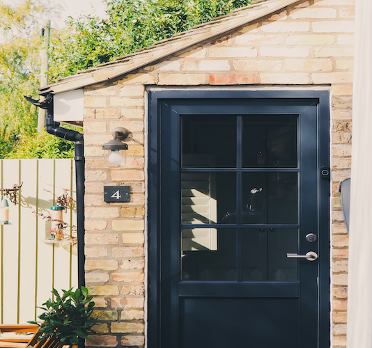 Black external door to yellow brick house