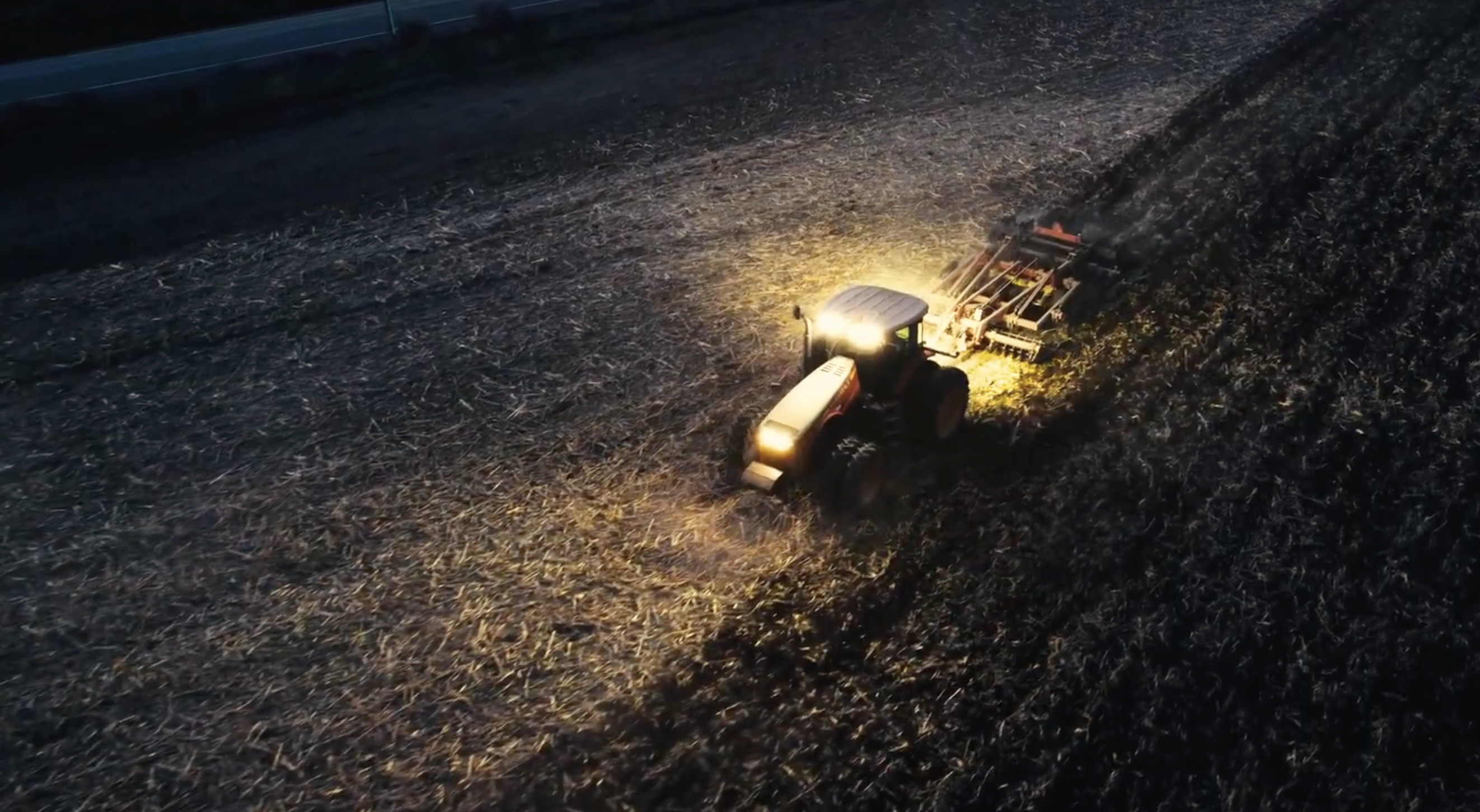 Versatile tractor in a field at night