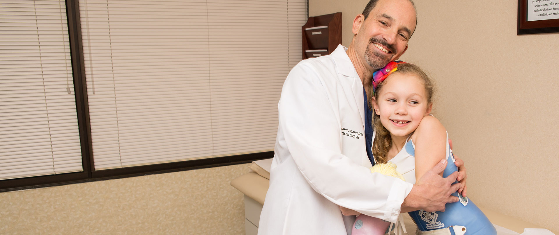 Doctor Mermelstein hugging a female pediatric patient