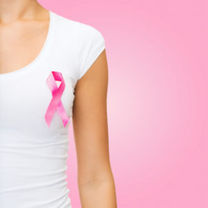 Woman wearing a pink ribbon for Breast Cancer Awareness Month