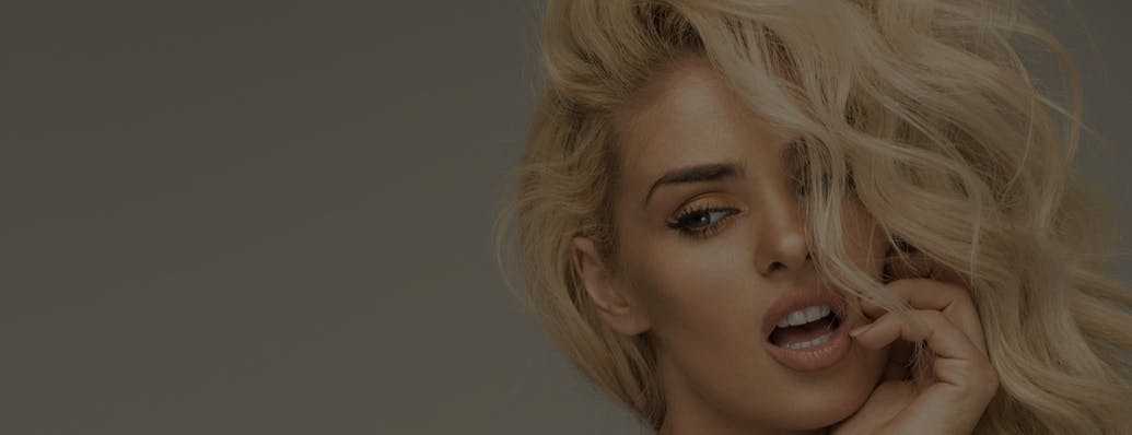 Beautfiul woman with long blonde hair looks at the camera in a studio shoot. Her wrinkle free face shows the potential results of BOTOX in Fort Lauderdale with Dr. Shuster