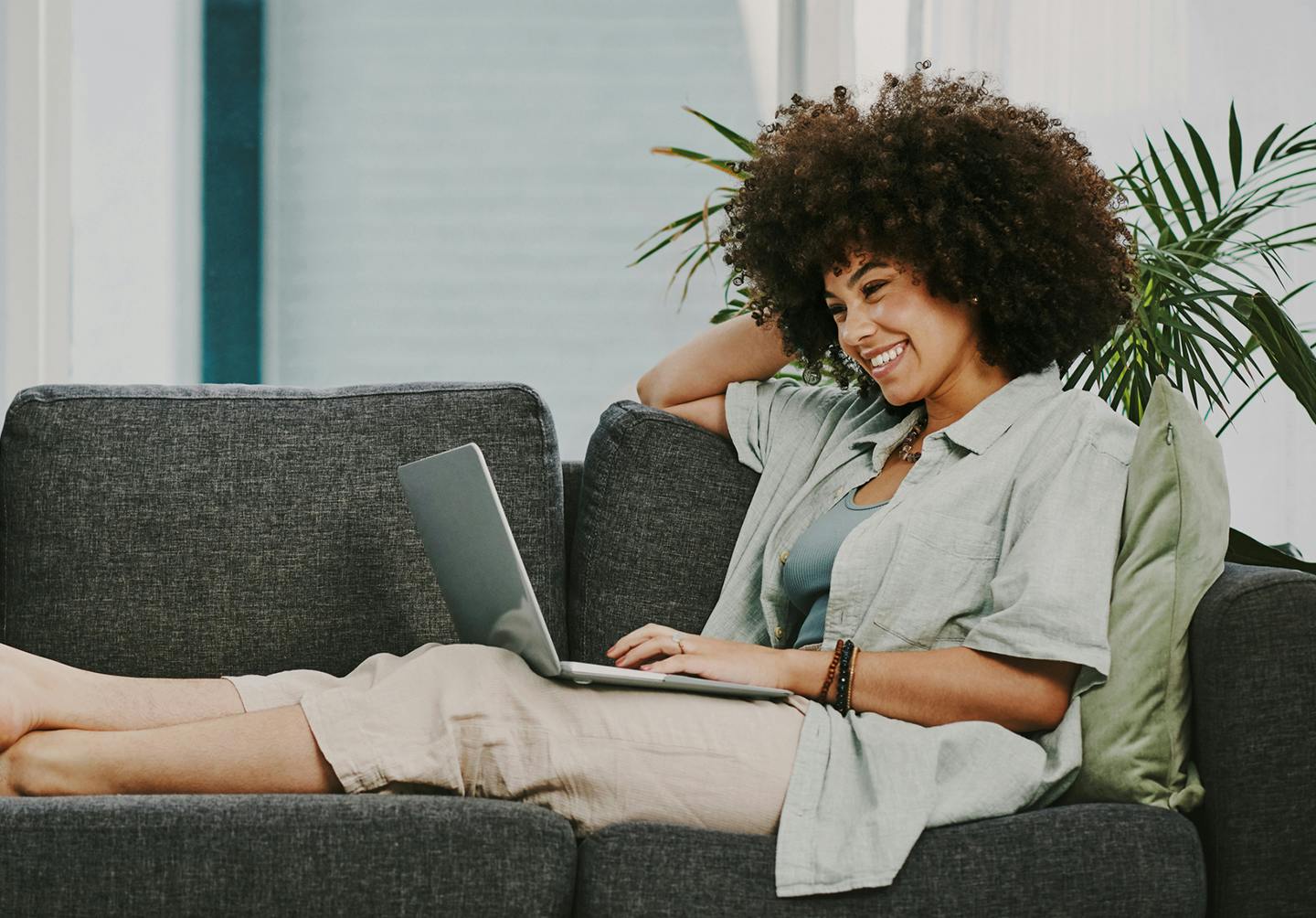 woman lounging on a couch on her laptop