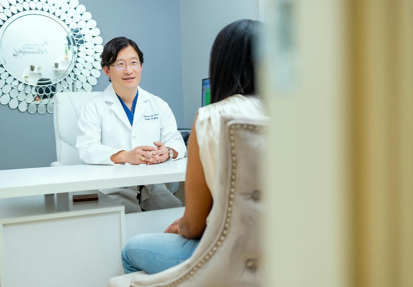 a patient talking with Dr. Lee in his office.