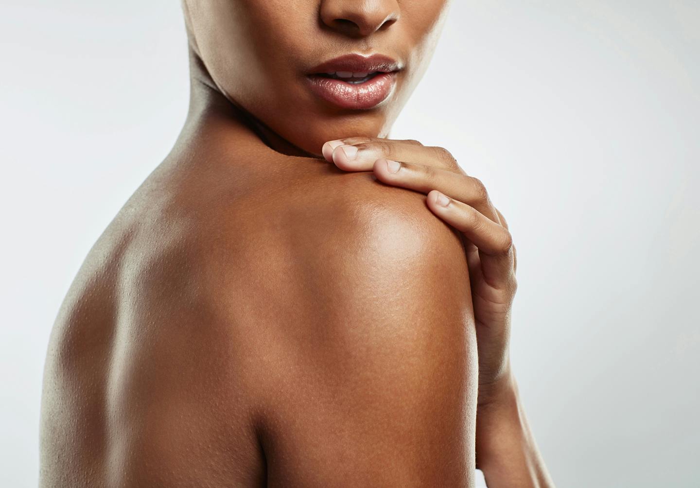 an image of a woman with smooth dark skin looking over her shoulder