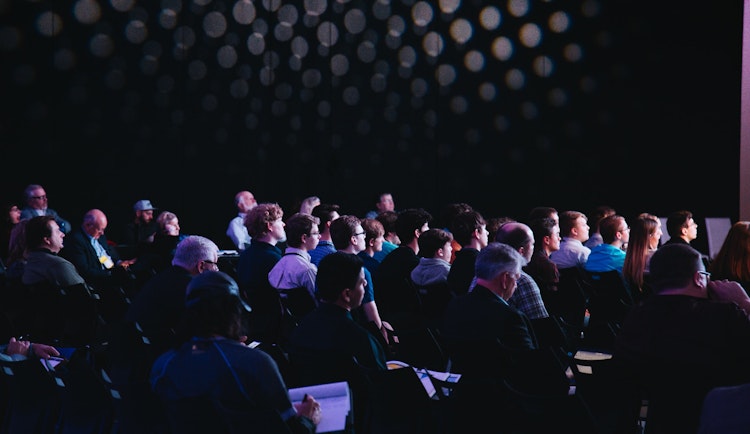 crowd of people sitting on chairs inside room
