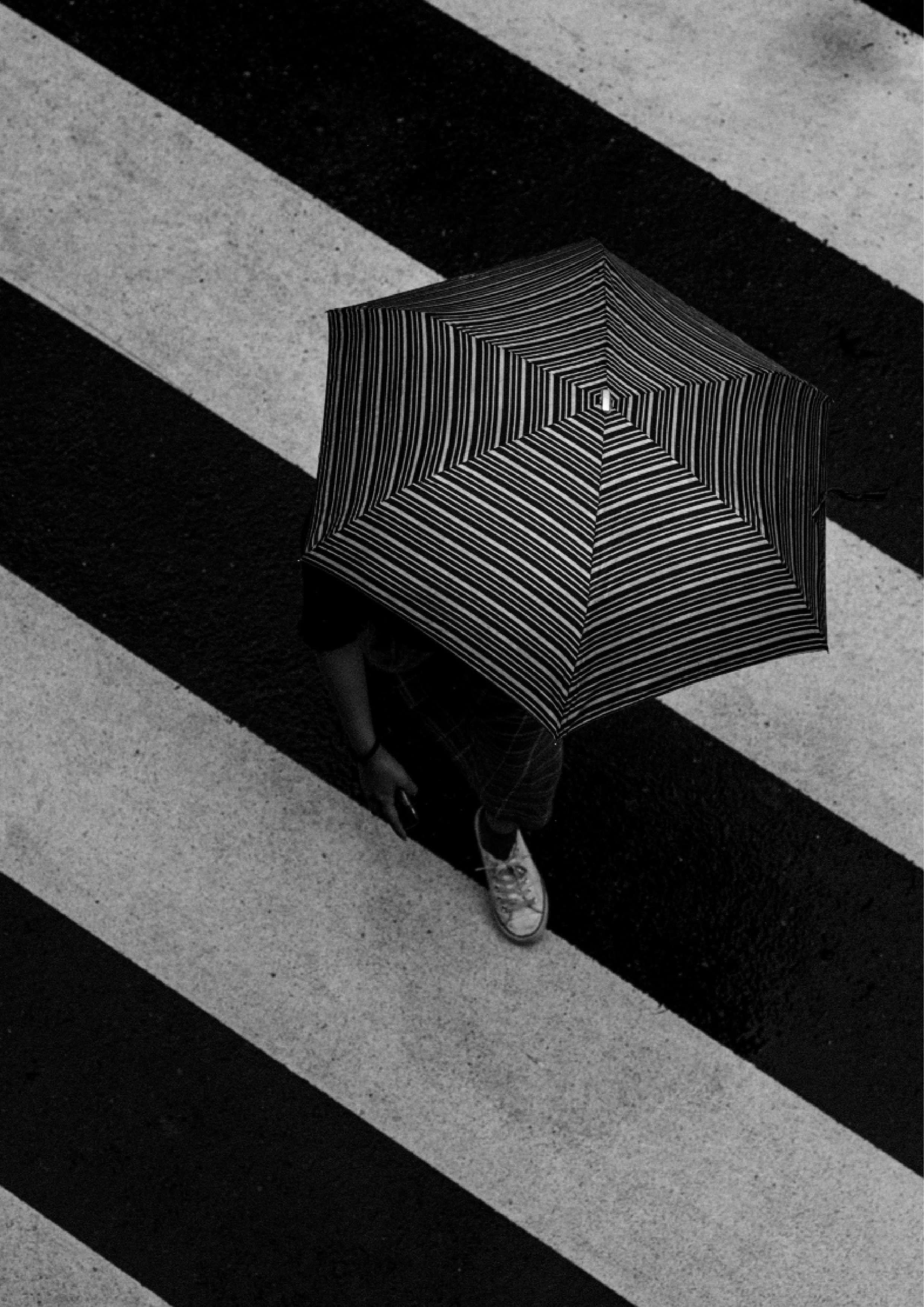 crossing the street with a black & white umbrella