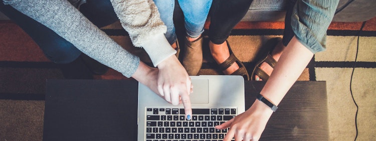 three person pointing the silver laptop computer
