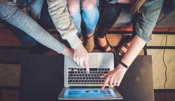 three person pointing the silver laptop computer
