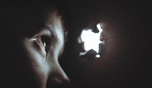 person watching through hole