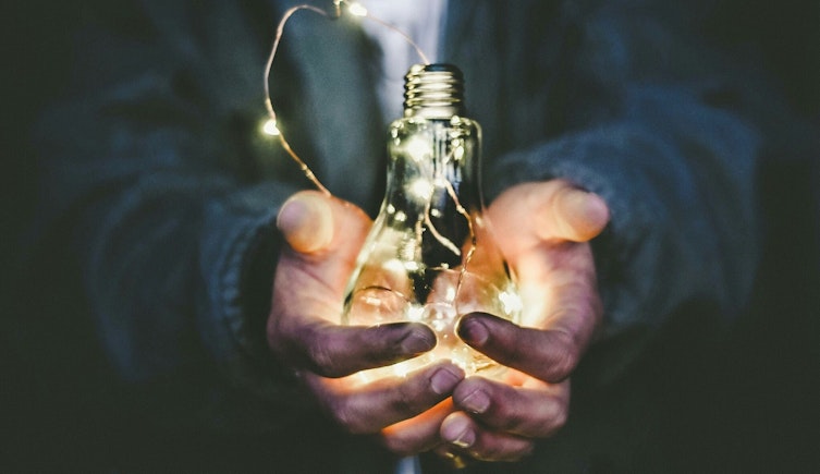 man holding incandescent bulb