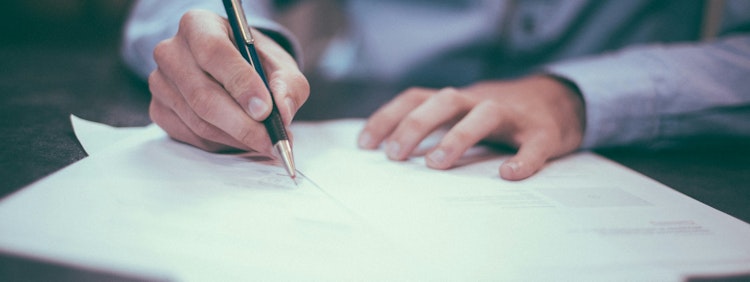 man writing on paper