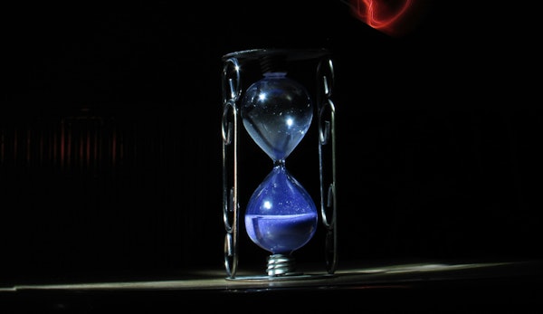 an hourglass sitting on a table in the dark