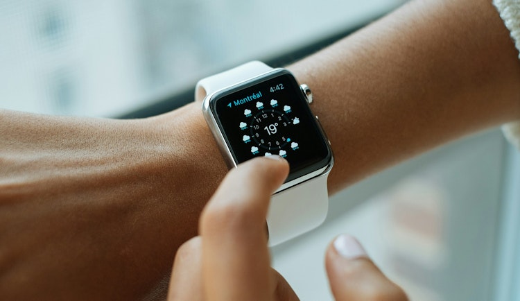 person wearing silver aluminium case Apple Watch with white Sports Band
