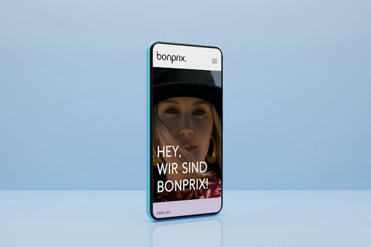Smartphone mit blauem Hintergrund zeigt die Startseite von bonprix Corporate