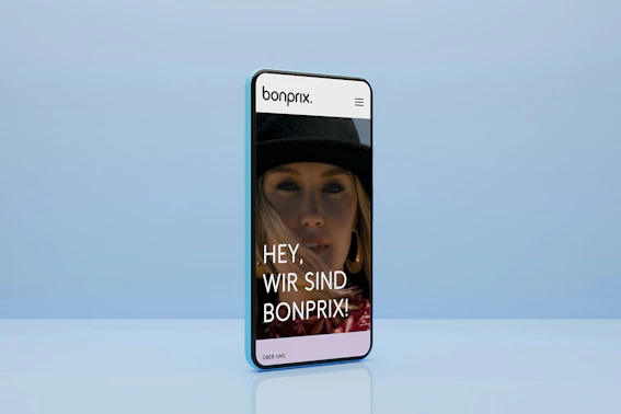 Smartphone mit blauem Hintergrund zeigt die Startseite von bonprix Corporate