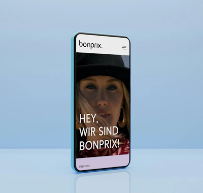 Smartphone mit blauem Hintergrund zeigt die Startseite von bonprix Corporate