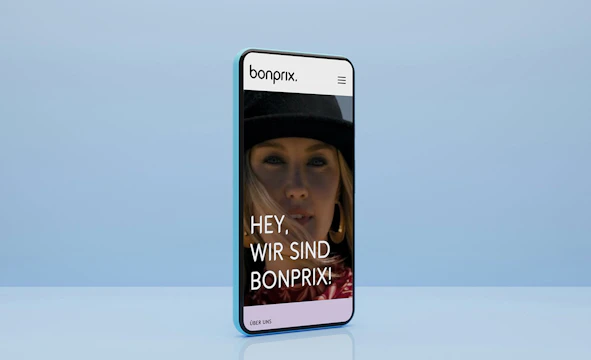 Smartphone mit blauem Hintergrund zeigt die Startseite von bonprix Corporate