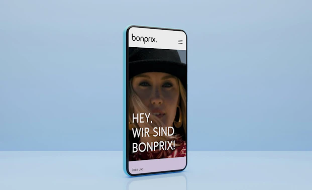 Smartphone mit blauem Hintergrund zeigt die Startseite von bonprix Corporate
