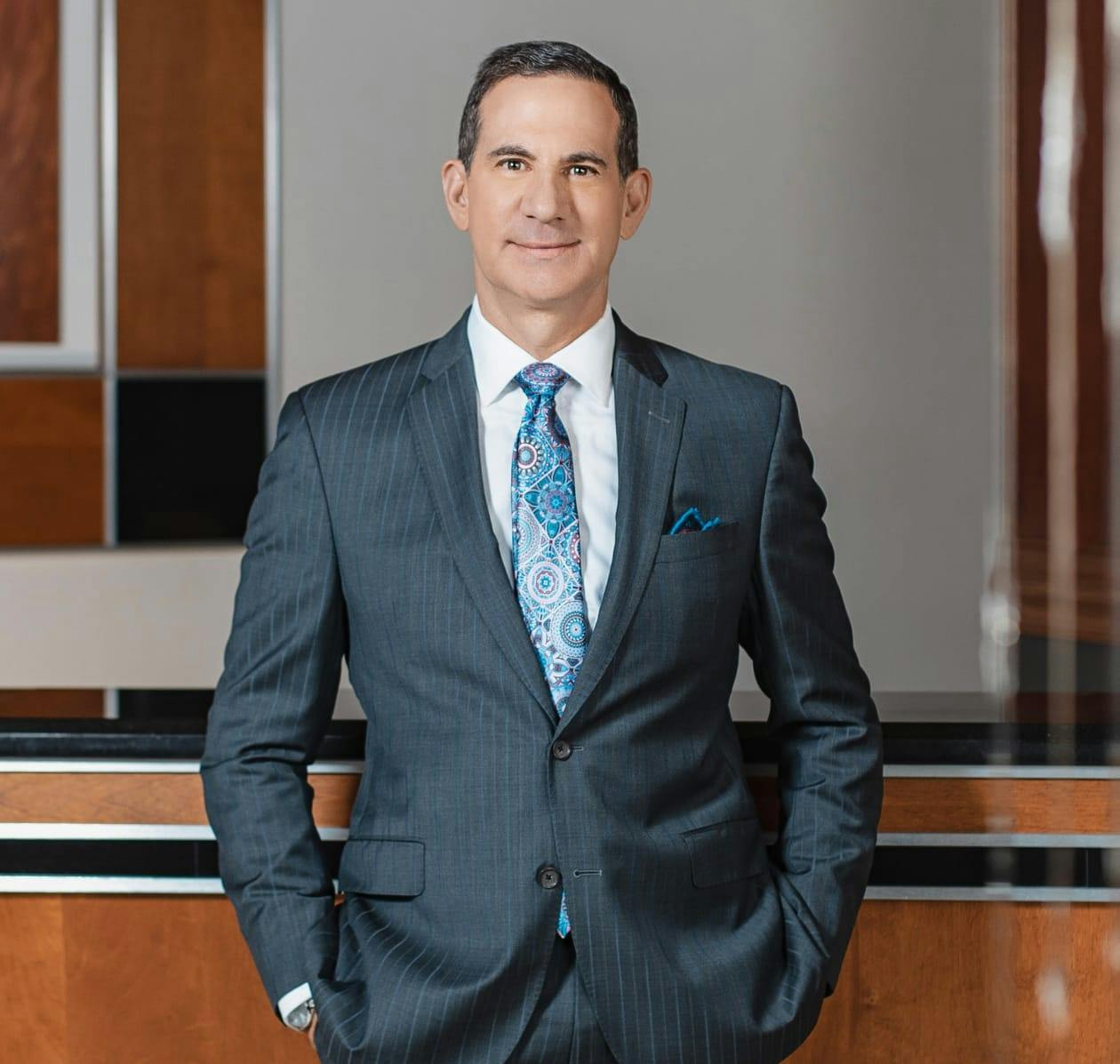 Photo of Dr. Clemens. He's wearing a suit and smiling into the camera.