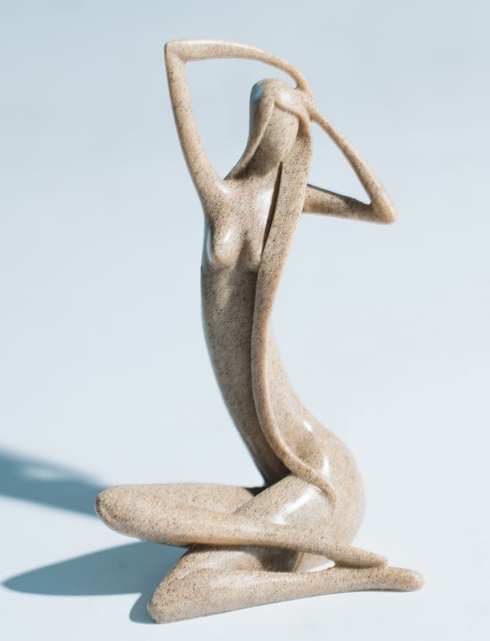 Sculpture of a woman sitting and touching her head