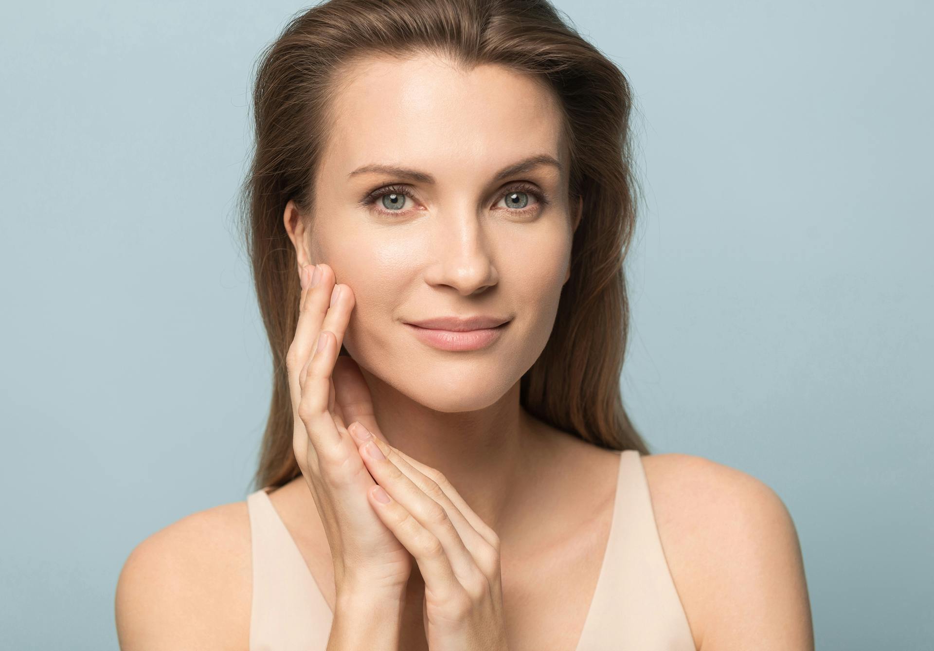 Woman with medium brown hair touching her face