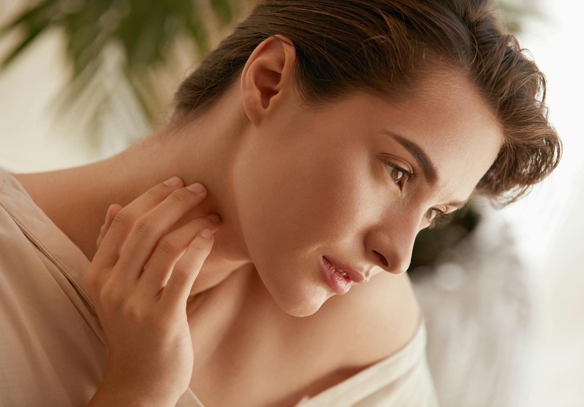 woman looking off touching her neck