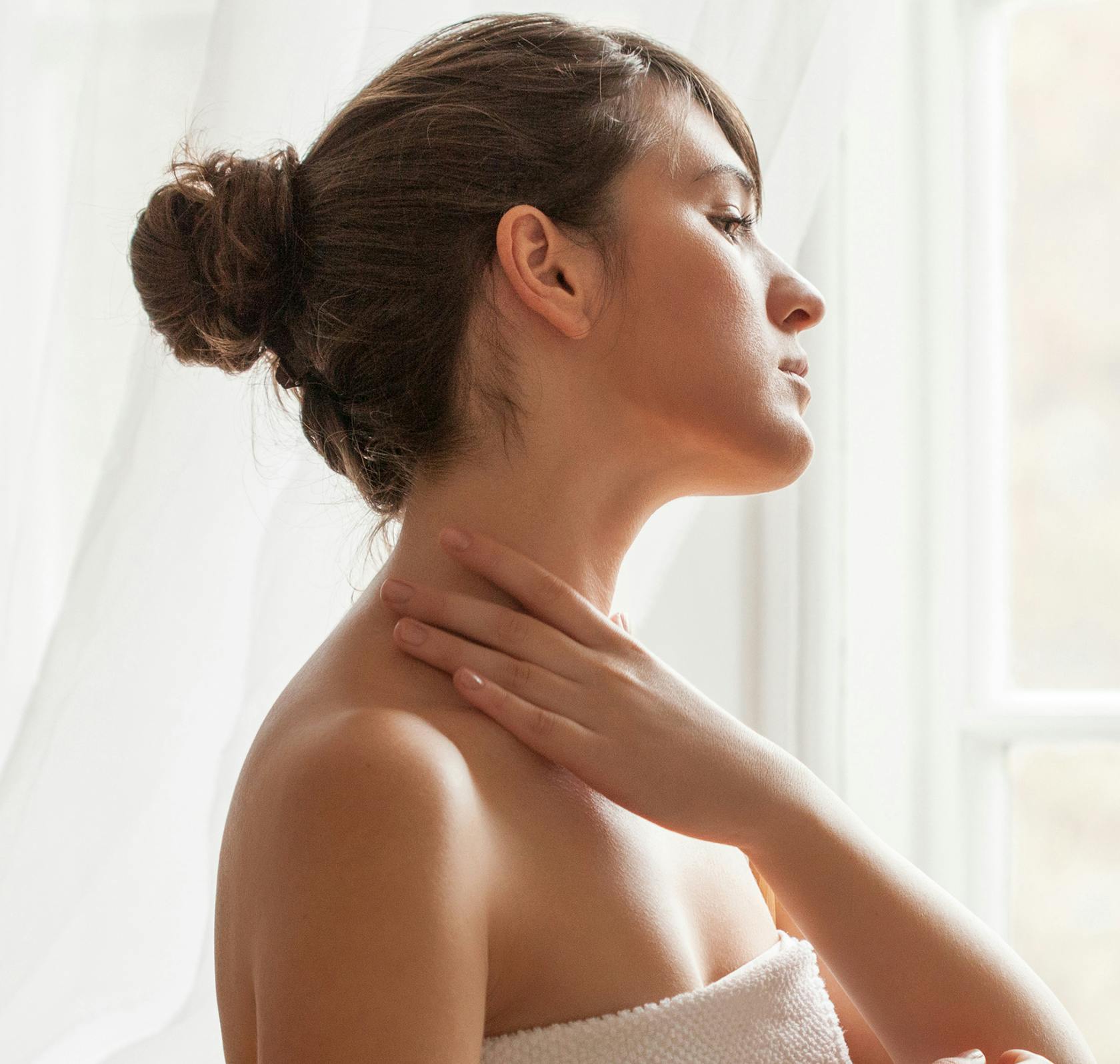 woman looking into the distance touching neck