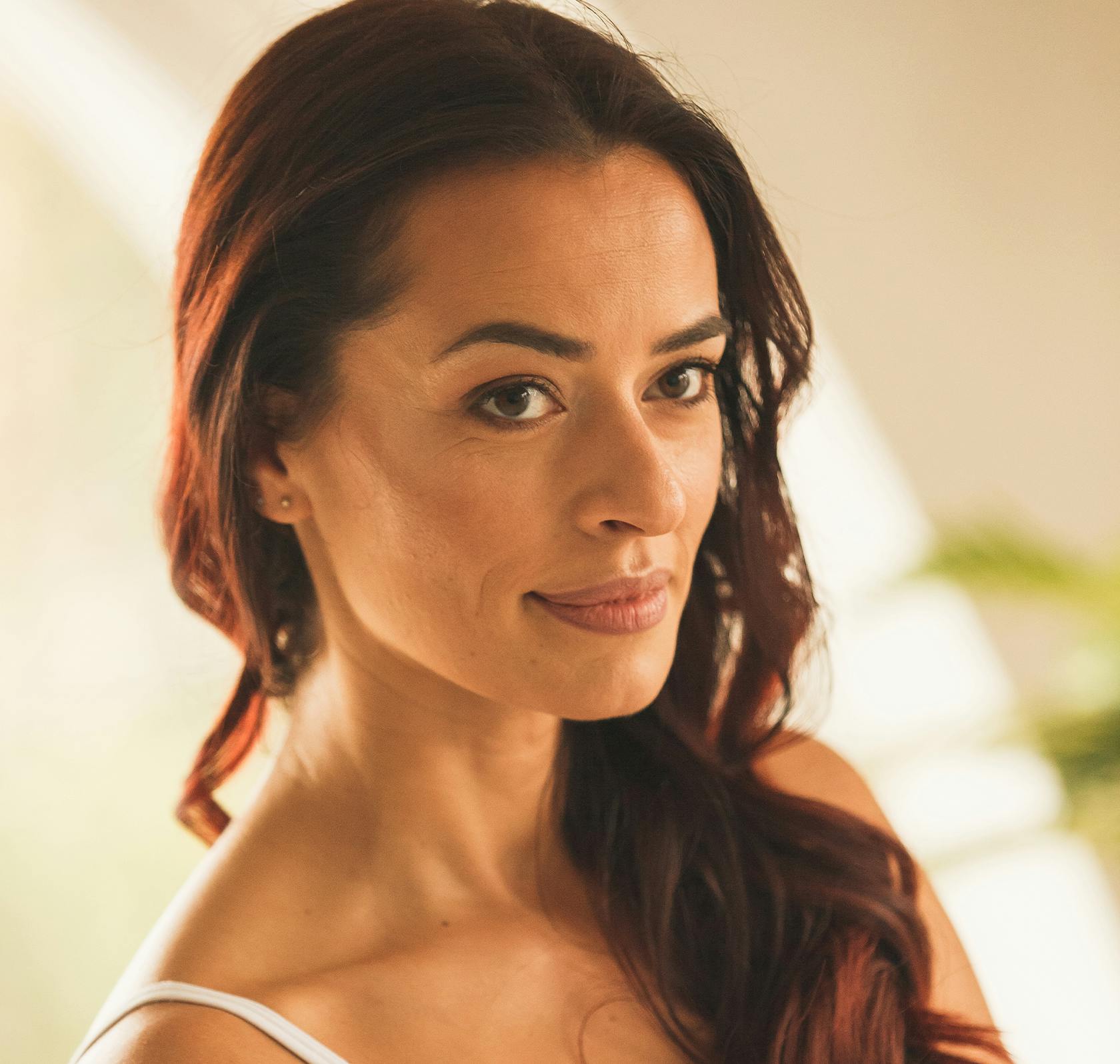 there is a woman with long red hair and a white top