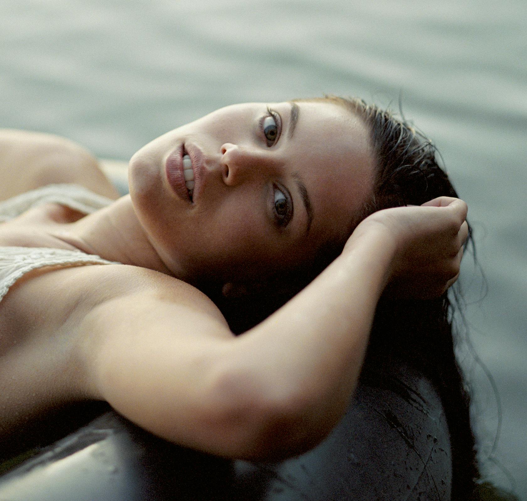 there is a woman laying on a raft in the water