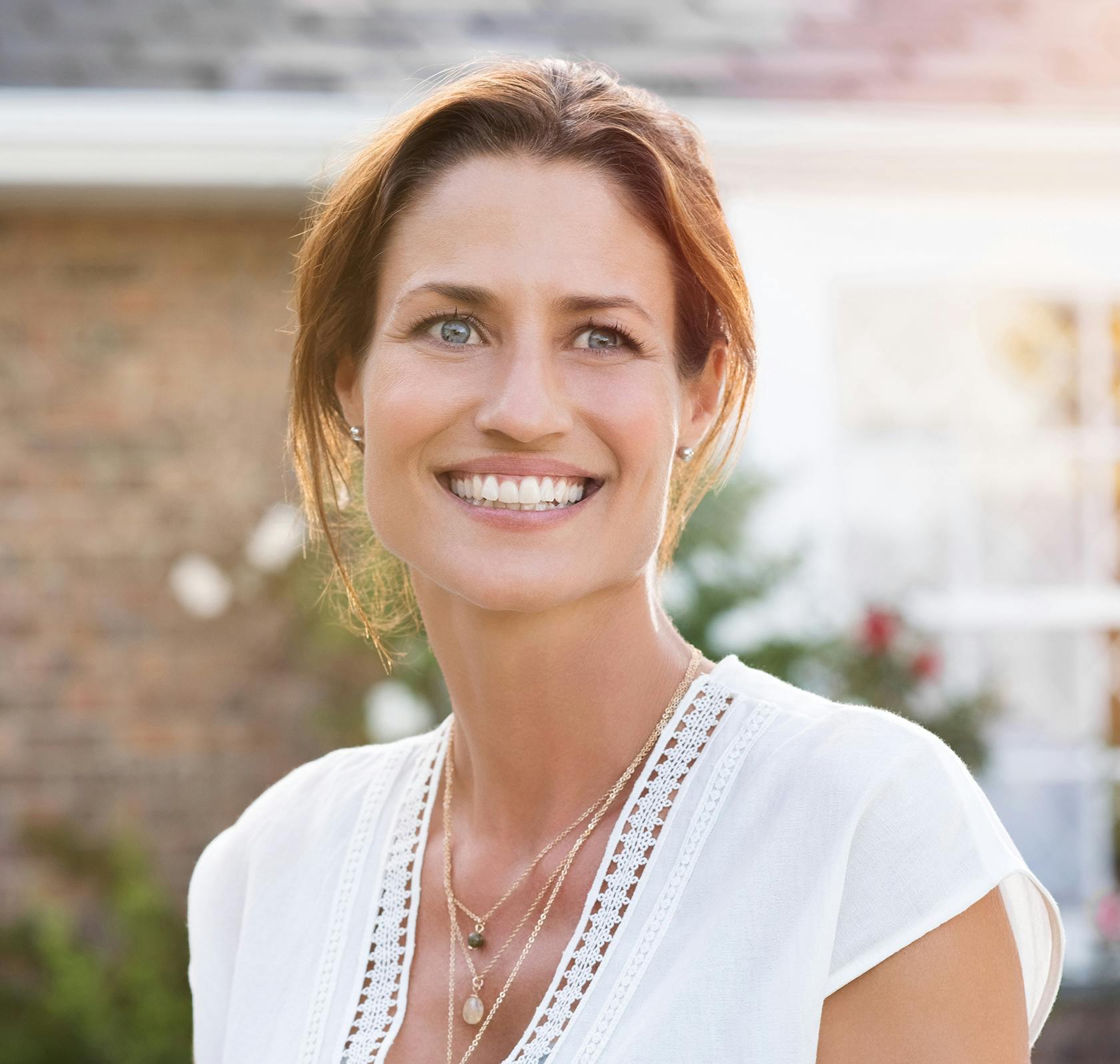 Pretty woman with red hair smiling outside