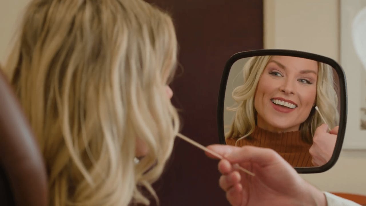 Female patient looking in a mirror and smiling