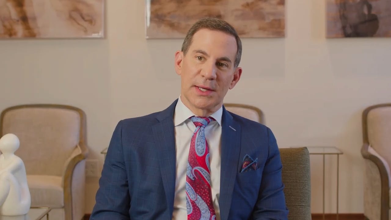 Dr. Clevens sitting and speaking in a blue suit