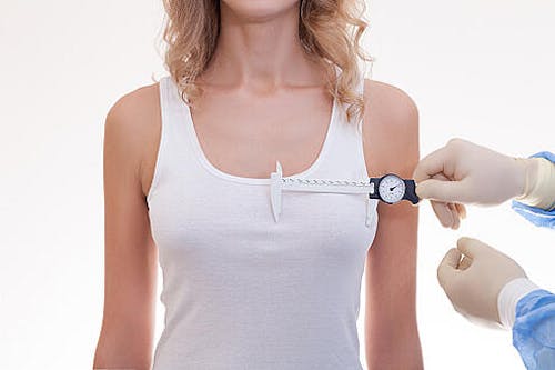 Doctor measuring woman's breast